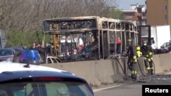 Rongsokan bus yang dibakar oleh sopirnya di sebuah jalan dekat Milan, Italia, Rabu (20/3). 