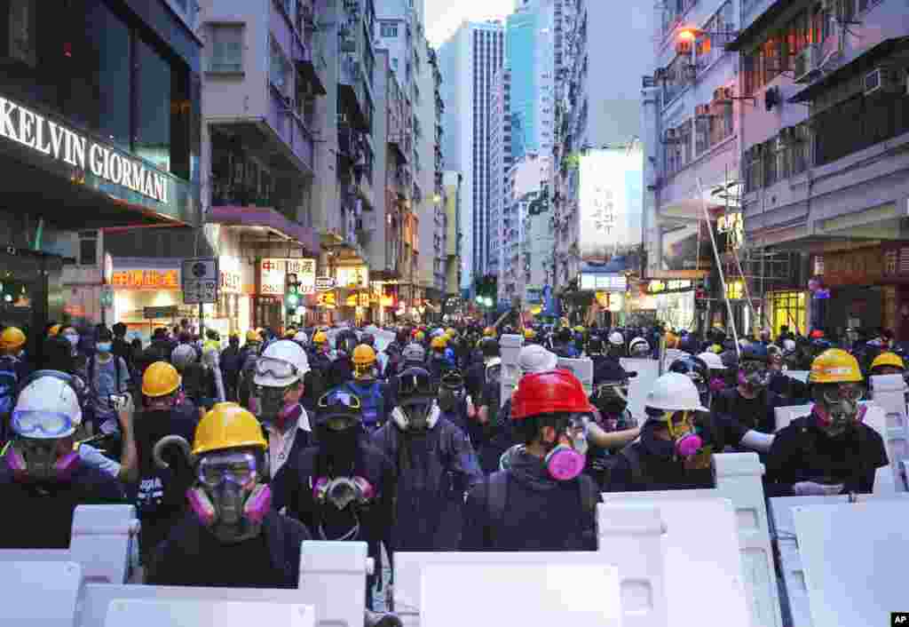 Manifestantes con equipo de protección se reúnen en Central, el principal distrito financiero de Hong Kong, el domingo 8 de septiembre de 2019, en una marcha pacífica al Consulado de EE.UU., para pedir al presidente Donald Trump &quot;liberar&quot; el territorio chino semiautónomo, pero la violencia estalló más tarde en Central después de que los manifestantes destrozaron las estaciones de metro, incendiaron y bloquearon el tráfico. (Foto AP / Kin Cheung)