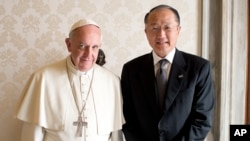 Pope Francis poses with World Bank President Jim Kim as they meet at the Vatican October 28, 2013.