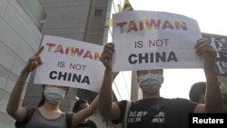 FILE - Activists protest against the Singapore meeting between Taiwan's President Ma Ying-jeou and China's President Xi Jinping on Nov. 7, 2015, outside the Ministry of Economic Affairs in Taipei, Taiwan.