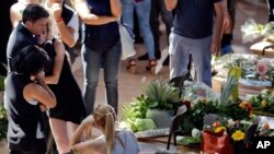 Italian Premier Matteo Renzi, left, comforts a woman at the end of the state funeral service for some of the victims of the earthquake that hit central Italy last Wednesday, in Ascoli Piceno, Italy, Aug. 27, 2016