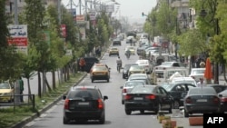 Những chiếc xe chạy trên đường của thành phố Homs đang bị vây hãm.