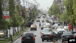 Cars drive on a street in a government-controlled district of Homs, May 7, 2014.