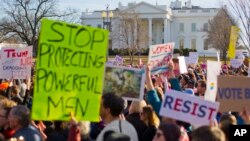 FILE - Women's March demonstrators walk past the White House in Washington, Jan. 20, 2018.