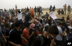 Palestinian protesters chant slogans during a protest at the Gaza Strip's border with Israel, east of Khan Younis, May 4, 2018. Palestinian protesters chant slogans during a protest at the Gaza Strip's border with Israel, east of Khan Younis, May 4, 2018.