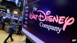 FILE -The Walt Disney Co. logo appears on a screen above the floor of the New York Stock Exchange, Aug. 8, 2017.