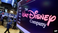 FILE - The Walt Disney Co. logo appears on a screen above the floor of the New York Stock Exchange, Aug. 8, 2017.