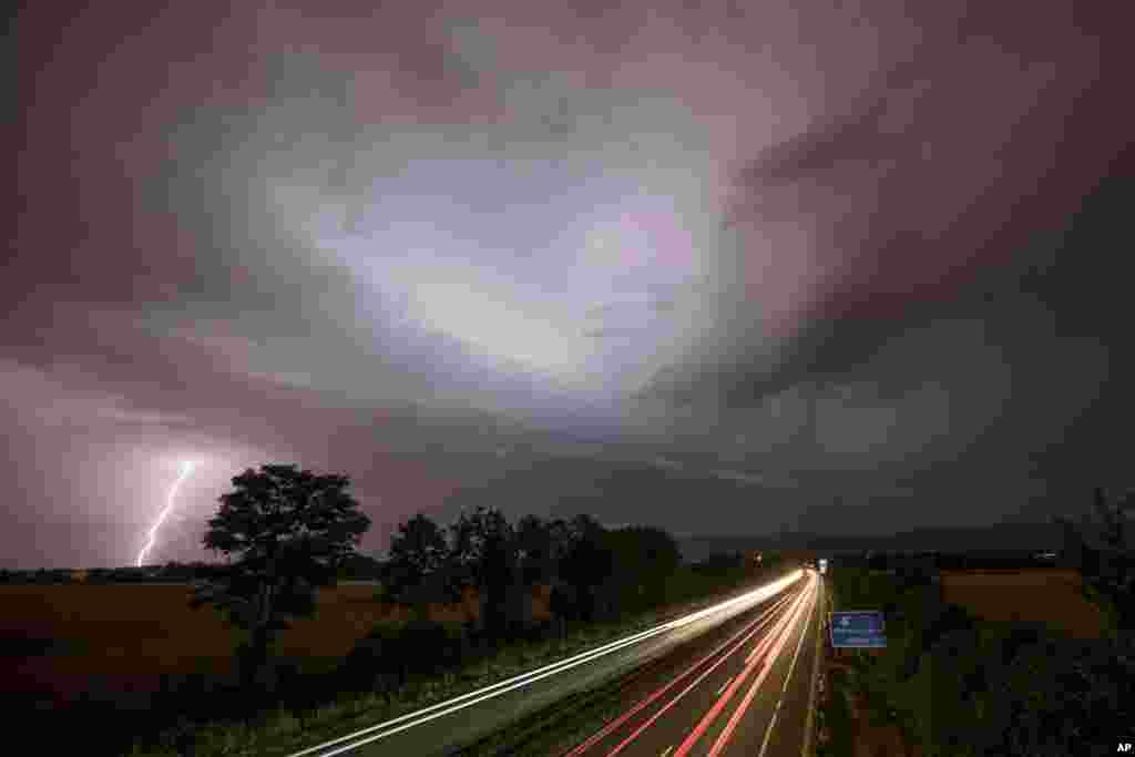Kilatan petir terlihat pada saat terjadi badai di jalan tol 661 di Oberursel, dekat kota Frankfurt, Jerman.