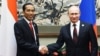 Russian President Vladimir Putin (r) shakes hands with Indonesian President Joko Widodo at the Asia-Pacific Economic Cooperation (APEC) forum in Beijing, Nov. 10, 2014. 