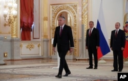 U.S. Ambassador Jon Huntsman walks after presenting credentials to Russian President Vladimir Putin, right, during a ceremony in the Kremlin in Moscow, Russia, on Tuesday, Oct. 3, 2017.