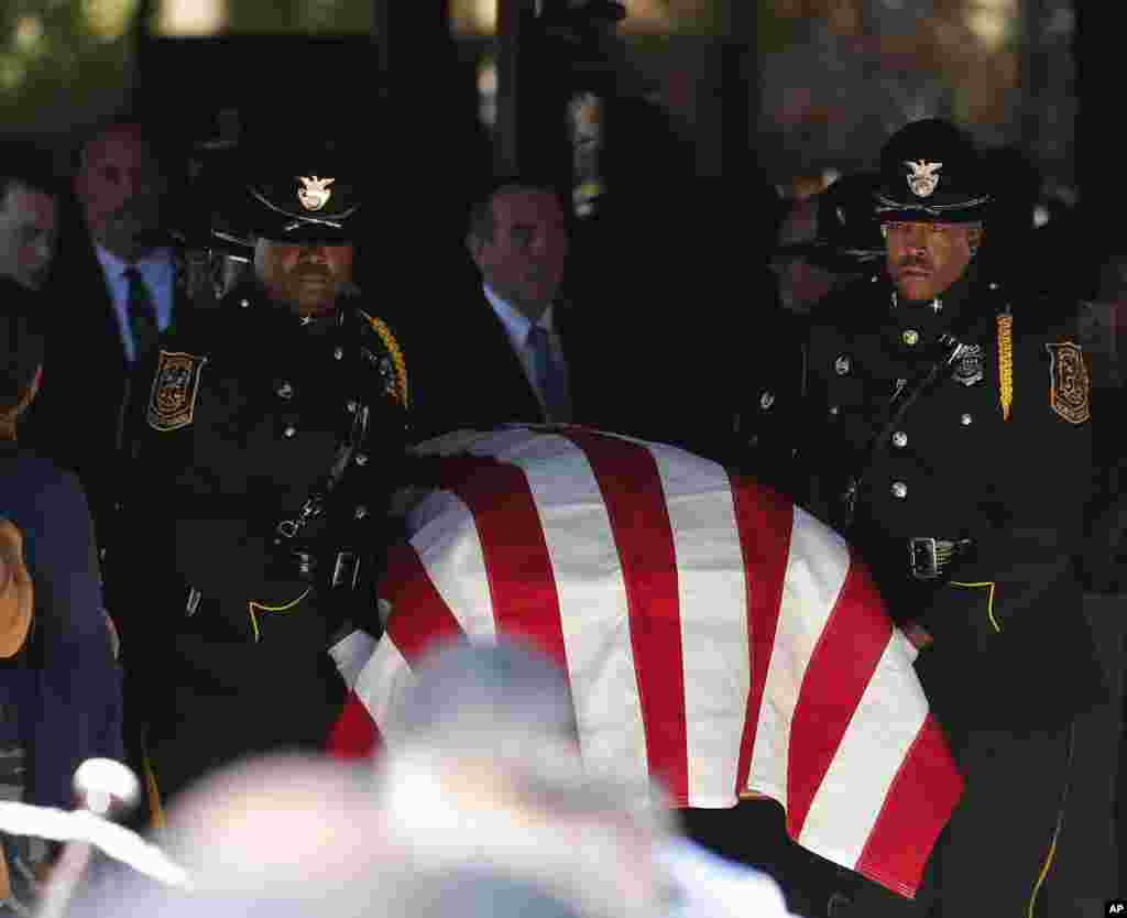 A police honor guard carries the casket out of All Saints Catholic Church after funeral service for Dekalb County Police officer Edgar Flores, in Dunwoody, Georgia, United States.