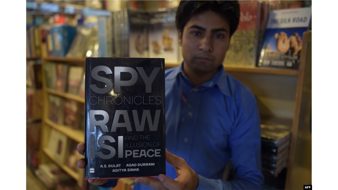 FILE - A Pakistani salesman shows "Spy Chronicles: RAW, ISI and the Illusion of Peace," co-written by Asad Durrani, a retired Pakistani army officer, at a bookstore in Islamabad, May 30, 2018.