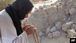 Mohamed Maouloud Ould Mohamed, un des maçons réparateurs des mausolées de Tombouctou, prie devant une tombe endommagée de Tombouctou, au Mali, 4 avril 2014.