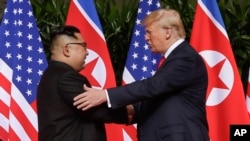 지난해 6월 싱가포르 카펠라 리조트에서 열린 첫 미-북 정상회담에서 도널드 트럼프 미국 대통령과 김정은 북한 국무위원장이 악수하고 있다.