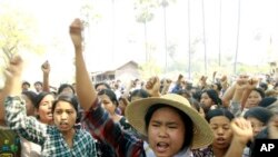 Villagers shout slogans during a protest against a recent report of a commission which investigated the Letpadaung mine's operations and a police crackdown last November that badly injured scores of protesters, during a visit by Myanmar opposition leader 