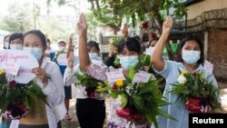 Perempuan membawa pot dengan bunga untuk mengambil bagian dalam protes terhadap kudeta militer di Yangon, Myanmar 13 April 2021. (Foto: Reuters)