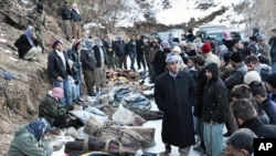 Locals gather in front of the bodies of people who were killed in a warplane attack in the Ortasu village of Uludere, in the Sirnak province, December 29, 2011.