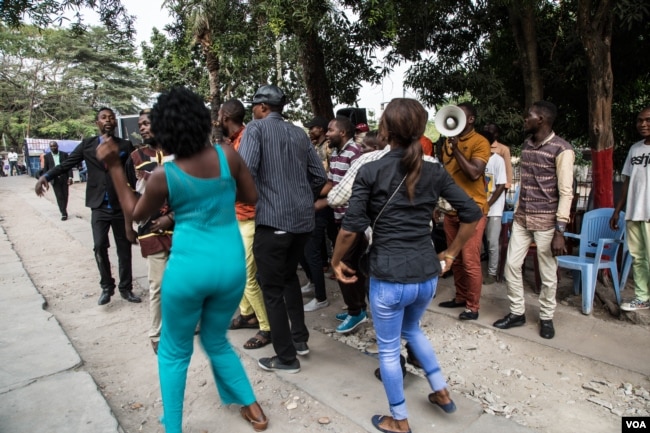 Young people dance on the grounds of the ruling PPRD party campaign office. (C. Oduah/VOA)