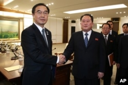 South Korean Unification Minister Cho Myoung-gyon, left, shakes hands with the head of North Korean delegation Ri Son Gwon after their meeting at the Panmunjom in the Demilitarized Zone in Paju, South Korea, Jan. 9, 2018.