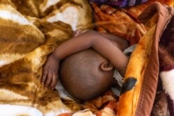 Un bébé dort à l'hôpital de Tudikolela, bénéficiaire de l'ONG ACF (Action contre la faim), dans la communauté de Lipemba, dans la région du Kasaï, en RDC, le 1 mai 2021.