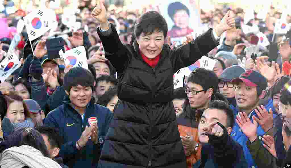 South Korea's presidential candidate Park Geun-hye of ruling Saenuri Party raises her arms during her presidential election campaign in Busan, South Korea, Dec. 18, 2012.