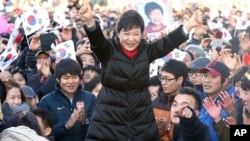 South Korea's presidential candidate Park Geun-hye of ruling Saenuri Party raises her arms during her presidential election campaign in Busan, South Korea, December 18, 2012.