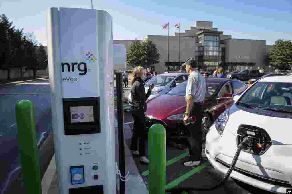 Guests gather around electric vehicles as NRG eVgo and Simon celebrate Earth Day with the opening of three new eVgo fast-charging Freedom Station sites across the greater Atlanta area,&nbsp;in Kennesaw, Ga., April 21, 2015.