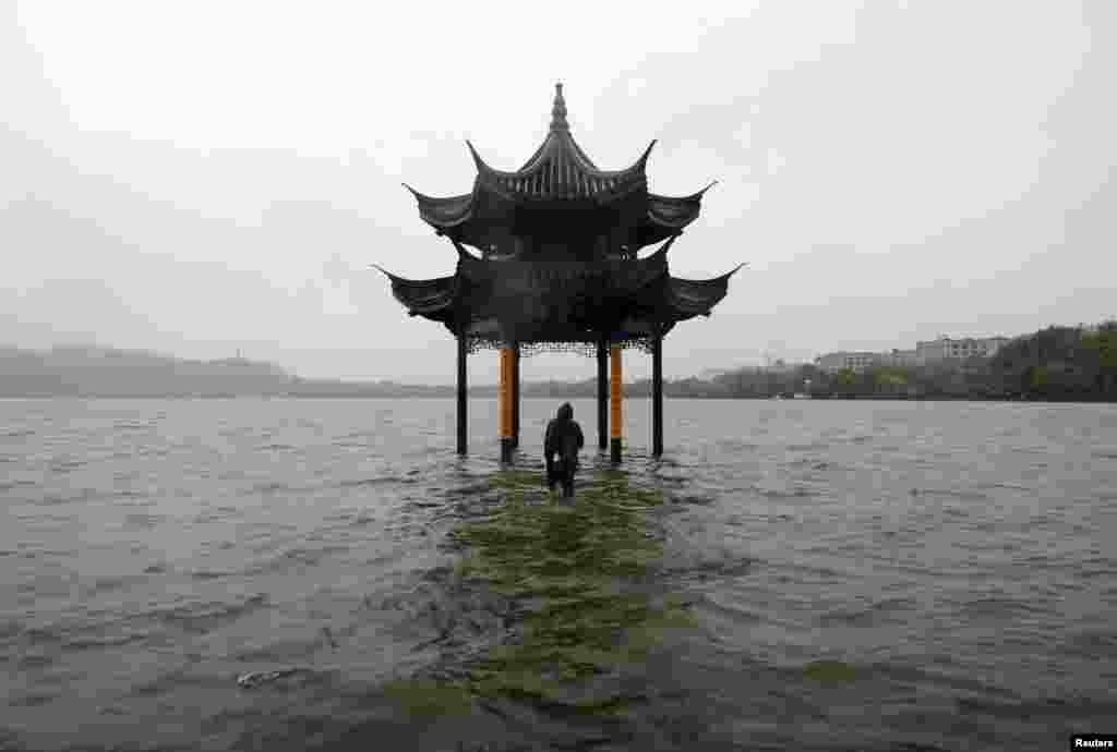 A man walks towards a flooded pavilion by the overflowing West Lake after Typhoon Fitow hit Hangzhou, Zhejiang province, China, Oct. 8, 2013. 