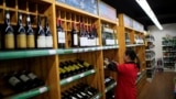A staff checks on bottles of wine at a supermarket in Shanghai, China, June 2, 2016. 