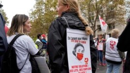 A medical worker holds a sign reading: 