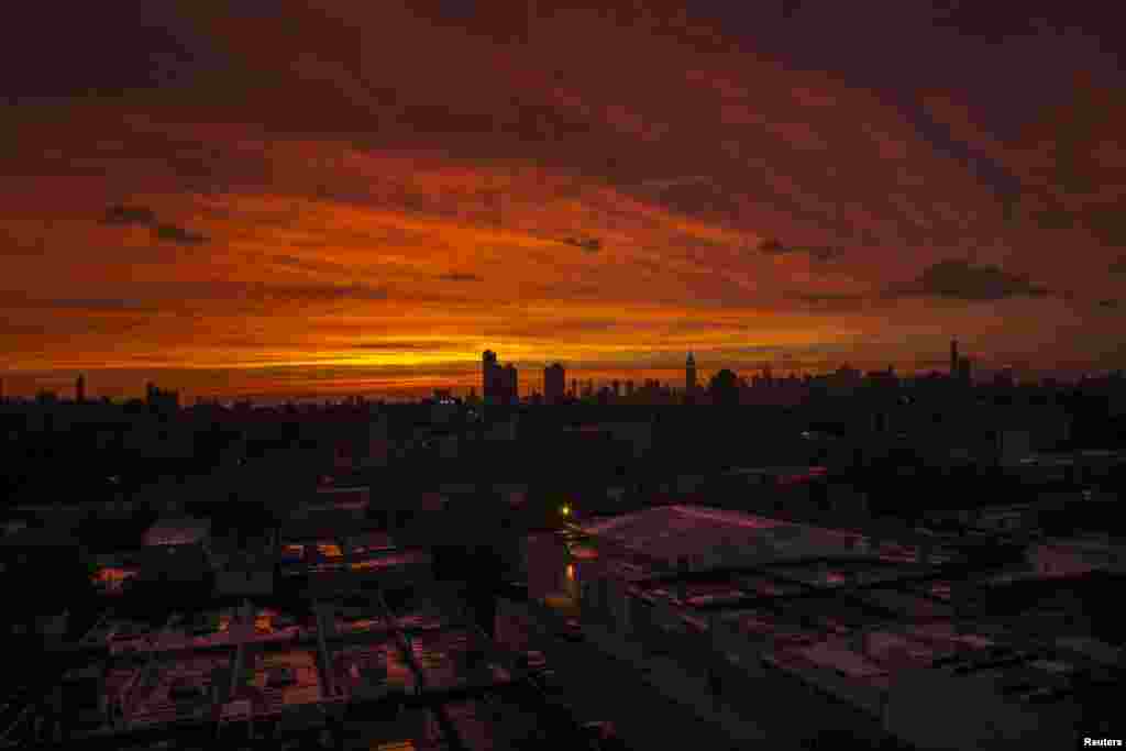 The sun sets over the skyline of New York after a rain storm, June 23, 2015.