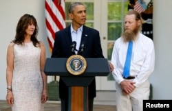 FILE - President Barack Obama stands with Bob Bergdahl, right, and Jami Bergdahl, left, as he delivers a statement about the release of their son, prisoner of war U.S. Army Sergeant Bowe Bergdahl, in the Rose Garden at the White House in Washington, May 31, 2014.