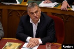 FILE - Hungarian Prime Minister Viktor Orban sits before vote on the 'Stop Soros' package of bills that criminalises some help given to illegal immigrants at the Parliament in Budapest, Hungary, June 20, 2018.