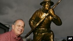 Artist Stephen Spears poses with his Doughboy bronze at a studio in Loveland, Colorado