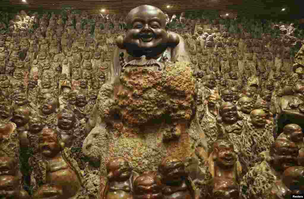 Buddha sculptures made of trunks of Chinese date trees are seen inside a company selling dates, in Zhengzhou, Henan province, China, Nov. 23, 2015. The room contains over 9,200 different buddha scluptures made of discarded Chinese date tree trunks, local media reported.