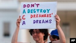 A protester holds up a sign during a rally supporting Deferred Action for Childhood Arrivals, or DACA, outside the White House, in Washington, Sept. 4, 2017. 