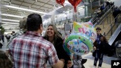 FILE - Nadia Hanan Madalo, center, hugs her brother Gassan Kakooz at the airport after arriving from Iraq, March 15, 2017, in San Diego. Madalo and her family, refugees forced to flee after the Islamic State invaded several years ago, arrived in San Diego