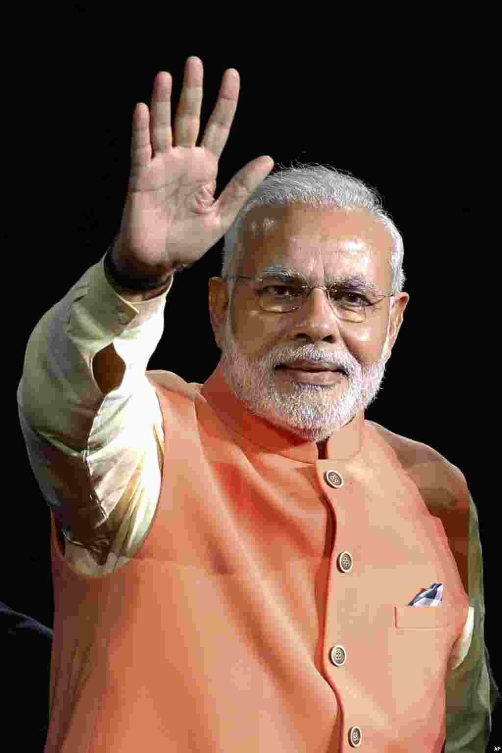 Prime Minister Narendra Modi of India waves as he is introduced before giving a speech during a reception by the Indian community in honor of his visit to the United States, at Madison Square Garden, New York, Sept. 28, 2014. 
