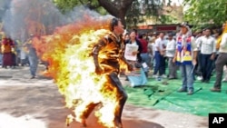 Jamphel Yeshi, a Tibetan exile, runs after setting himself on fire during a protest against the upcoming visit of Chinese President Hu Jintao to India in New Delhi, March 26, 2012.