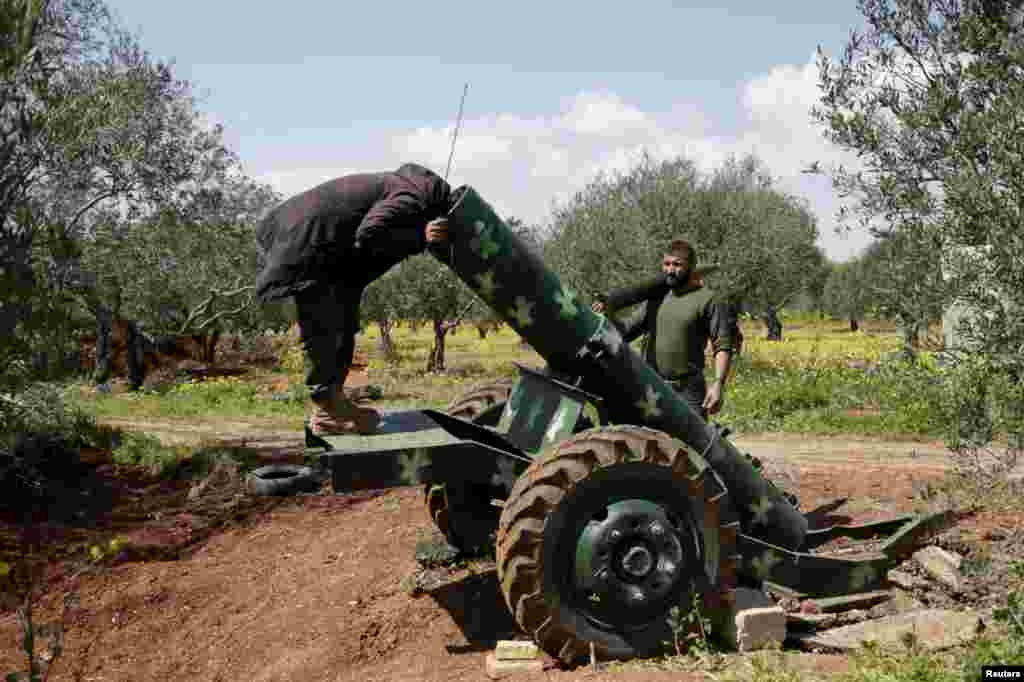 A rebel fighter looks inside a cannon near Idlib in northern Syria, March 23, 2015.