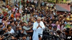 ຜູ້ປົກຄອງລັດ Bihar ທ່ານ Nitish Kumar (ກາງ) ມີບັນດານັກຂ່າວ ແລະ ຝຸງຊົນຕິດຕາມ ອ້ອມທຸກດ້ານ ຂະນະທີ່ທ່ານທັກທາຍ ປະຊາຊົນຜູ້ສະໜັບສະໜູນ ຫຼັງຈາກ ຊະນະການເລືອກຕັ້ງຂັ້ນລັດ ໃນເມືອງ Patna ປະເທດອິນເດຍ ເມື່ອວັນອາທິດ ທີ 8 ພະຈິກ 2015.