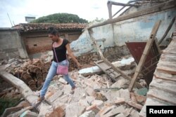 Una indígena zapoteca Muxe camina sobre los escombros de su casa destruida por el terremoto que estremeció la costa sur de México el jueves 7 de septiembre. Juchitán, Mexico, Sept. 10, 2017.