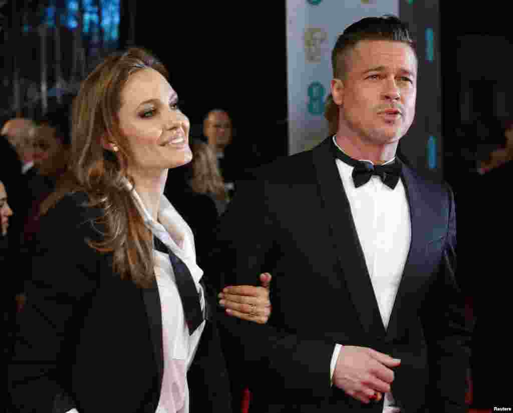 Os actores Brad Pitt (D) e Angelina Jolie chegam aos Prémios BAFTA da Academia Britânica de Artes e Cinema, na Royal Opera House em Londres Fev. 16, 2014. REUTERS/Suzanne Plunkett&nbsp; 