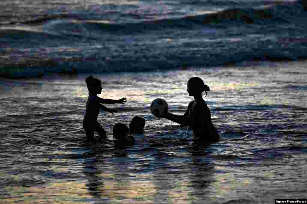 Children play in the Indian Ocean during sunset at a beach in Galle, Sri Lanka, Nov. 20, 2021.
