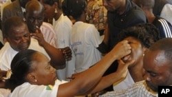 A aid worker left, vaccinates a woman, right, during a polio immunization campaign in Brazzaville, Republic of Congo (File Photo)