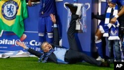 L'entraîneur-chef de Chelsea, José Mourinho, couché sur la pelouse, célèbre la victoire de son équipe à la finale de la Coupe de la Ligue anglaise à la fin du match entre Chelsea et Tottenham, au stade de Wembley à Londres, 1er mars 2015. 