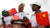 Tanzanian women wait for China's President Xi Jinping to arrive at Julius Nyerere International Airport in Dar es Salaam, March 24, 2013. 