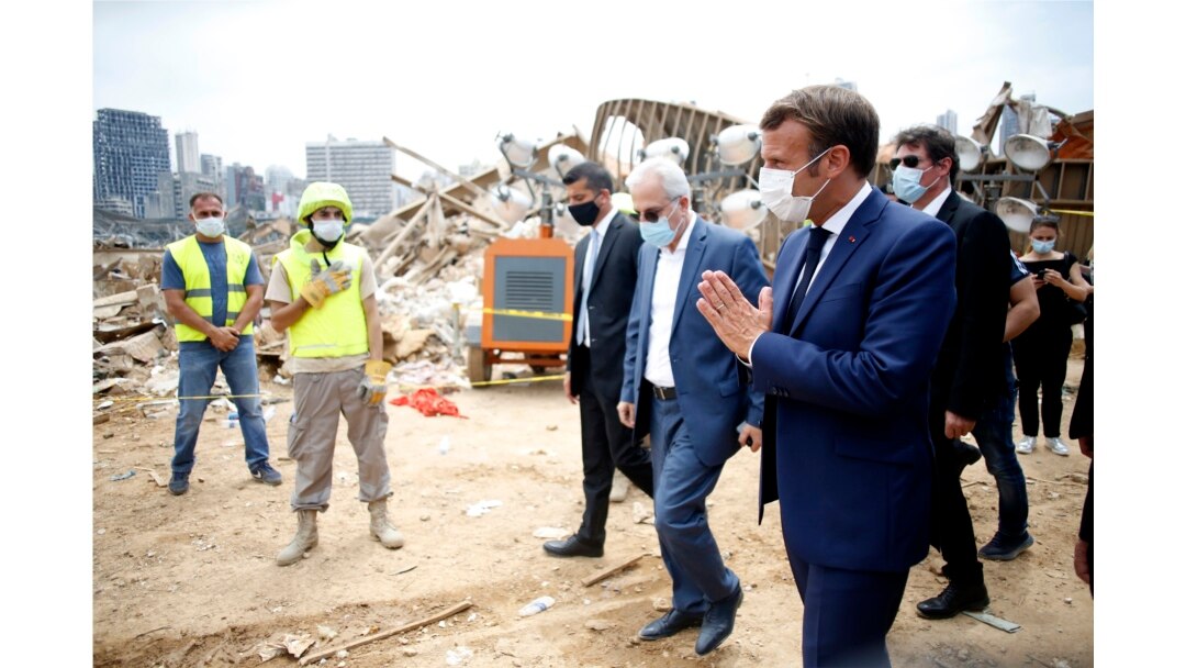 Presiden Perancis Emmanuel Macron (kanan) memberikan salam dengan isyarat tangannya kepada regu penyelamat setibanya di lokasi ledakan di pelabuhan Beirut, Lebanon, Kamis 6 Agustus 2020.
