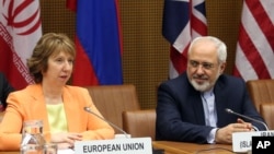 European foreign policy chief Catherine Ashton (L) and Iranian Foreign Minister Mohamad Javad Zarif, wait for the start of closed-door nuclear talks in Vienna, Austria, Mar. 19, 2014.