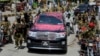 FILE - A vehicle carrying Syed Salahuddin, the leader of the Hizbul Mujahideen, is escorted by his supporters as he arrives for a press conference in Muzaffarabad, the capital of Pakistani-controlled Kashmir, July 1, 2017. 